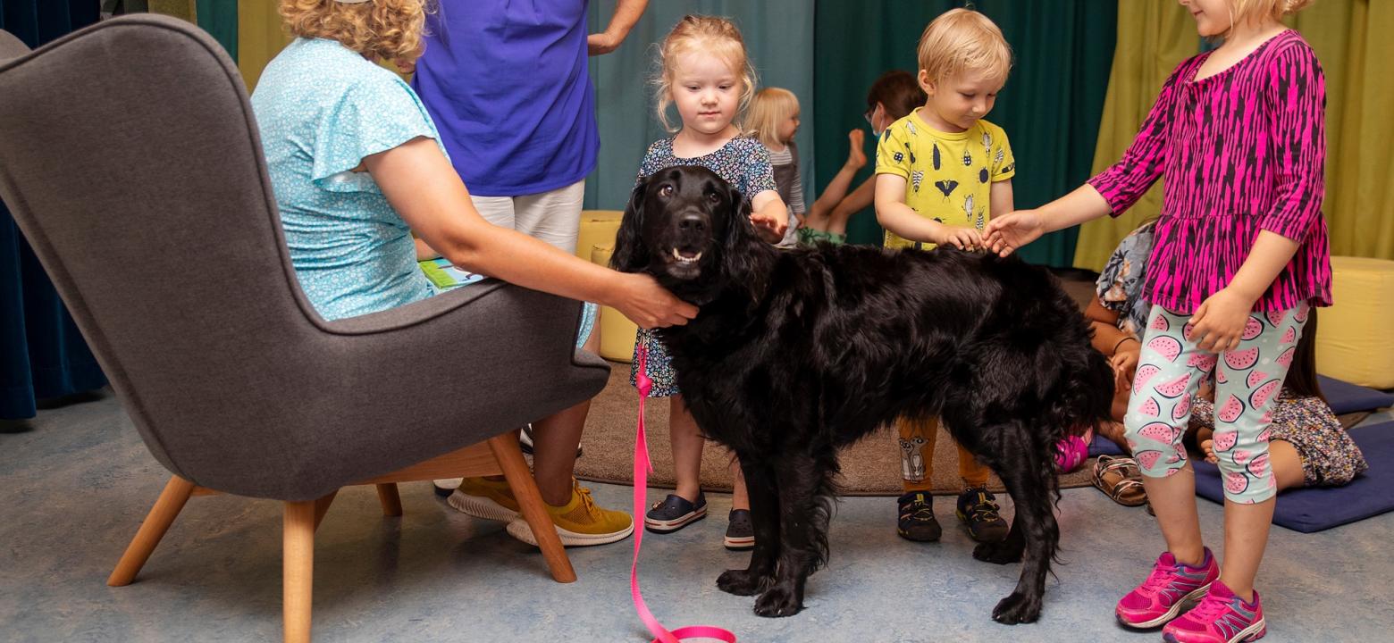 Barn tillsammans med läshunden Ninni, en svart labrador. 